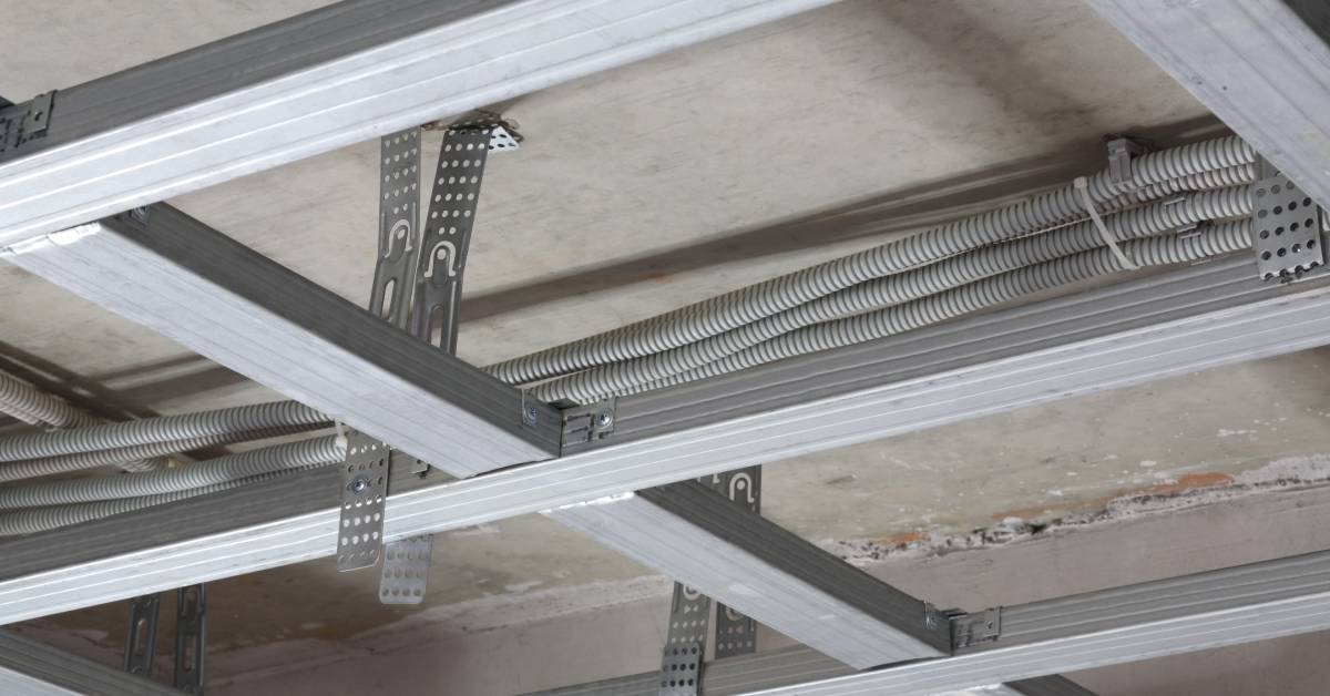 Aluminum profiles serving as structural support for a ceiling frame. They are installed in a lateral pattern.